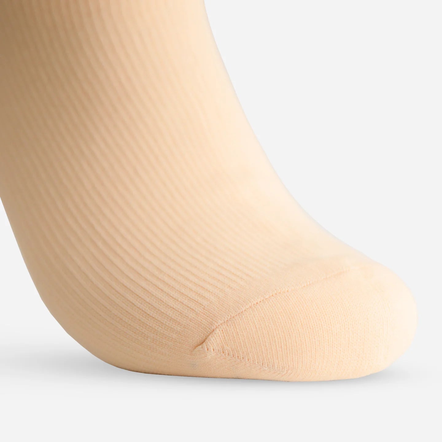 close-up of a soft ivory sock on a foot from side