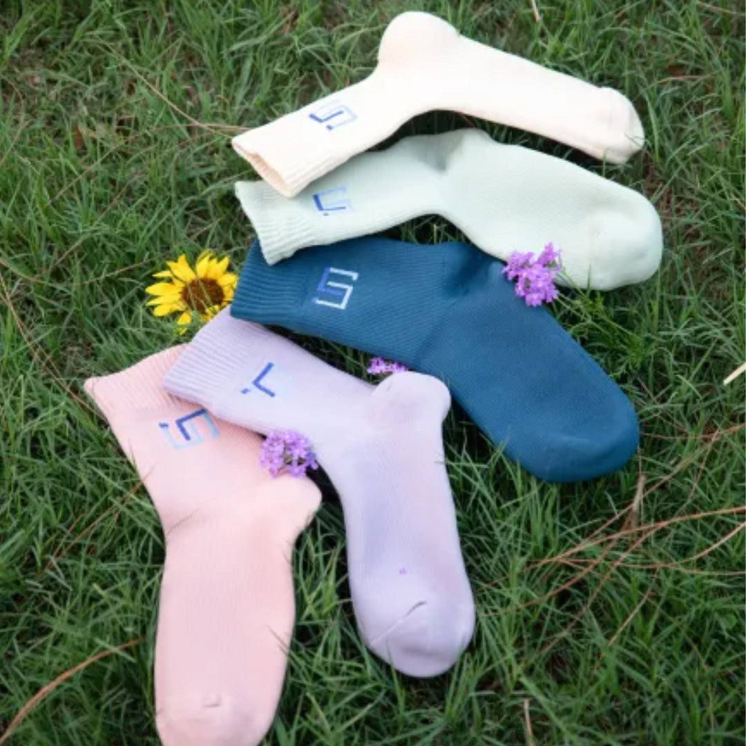 nisa collection socks placed on grass in an outdoor setting