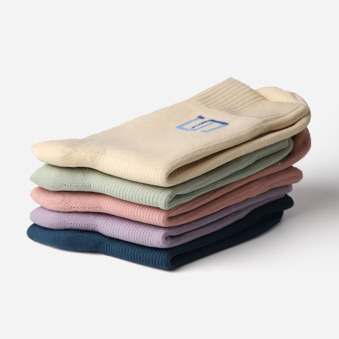 stack of colorful socks with the wudhu socks brand logo