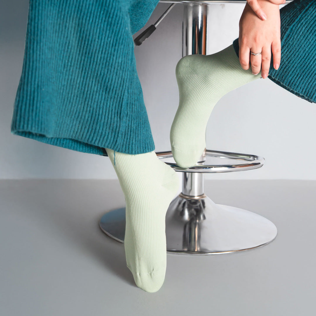 woman wearing pastel green socks sitting on a chair