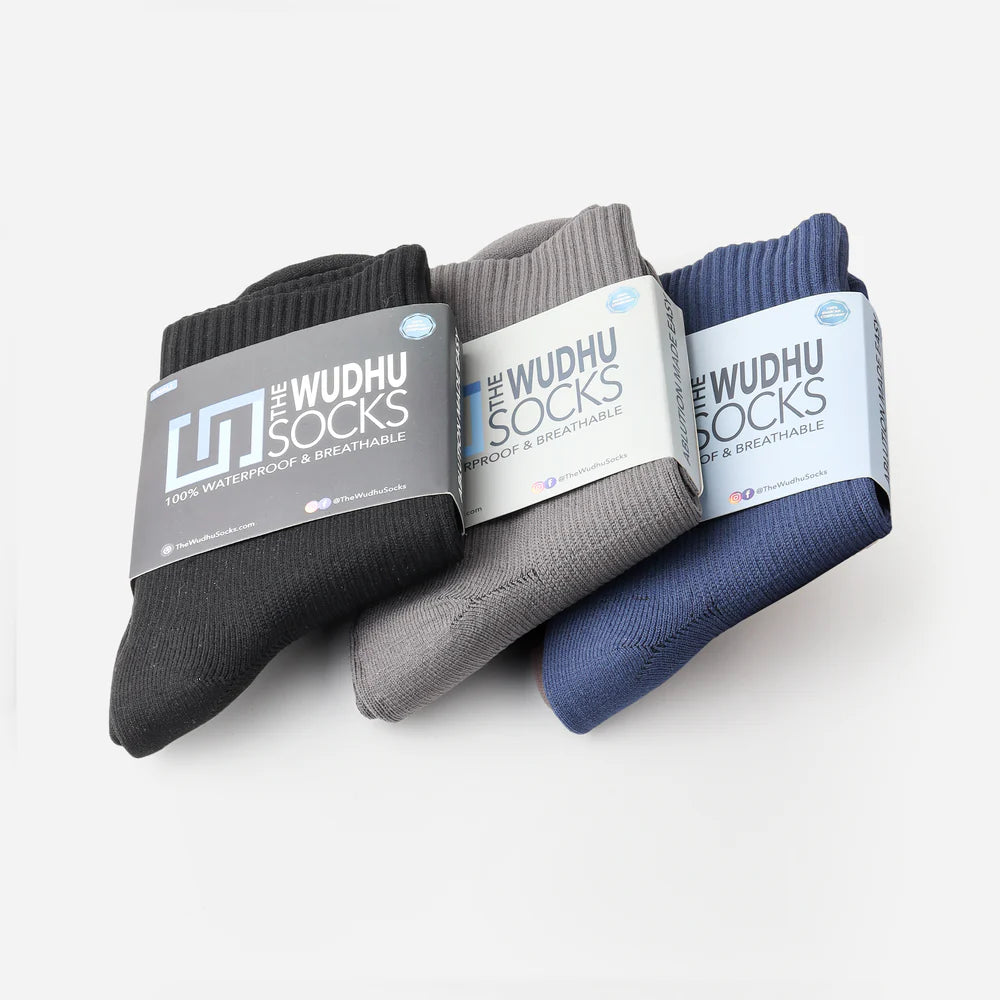 three packs of socks, each pack containing a set of socks in different colors (jet black, stone gray, and navy blue), with 'the wudhu socks' logo
